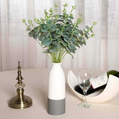 Modern vase with eucalyptus arrangement on a table setting.
