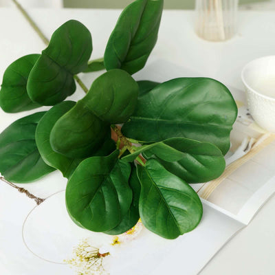 Faux fiddle leaf fig leaves on a table with decor elements.