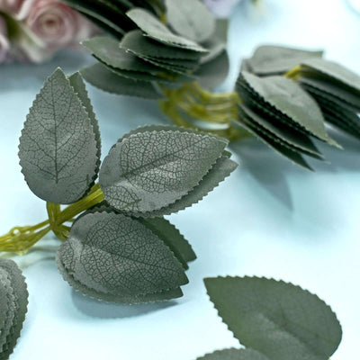 Green artificial leaves on a light blue background.