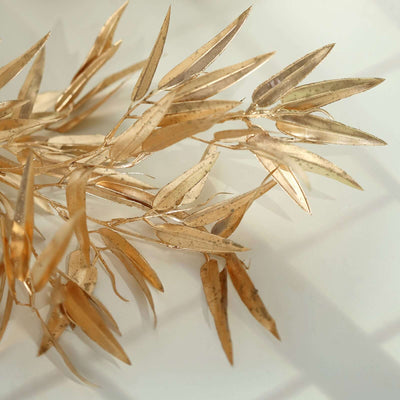 Gold leaf branches on a light surface