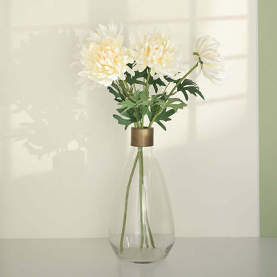 Clear glass vase with white flowers and green leaves