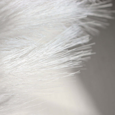 Close-up of white fluffy texture with fine fibers.