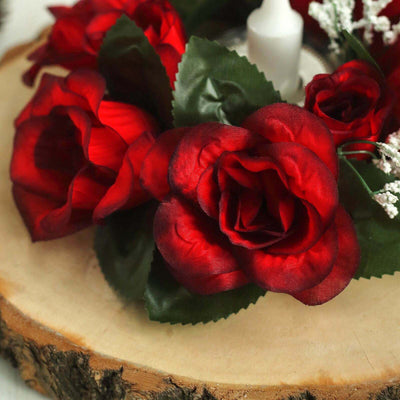 Red artificial roses arrangement on a wooden slice.