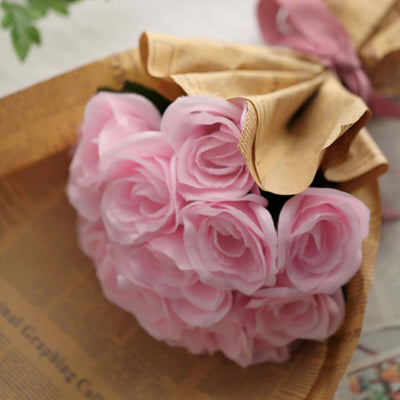 Bouquet of pink roses in a decorative paper wrap.