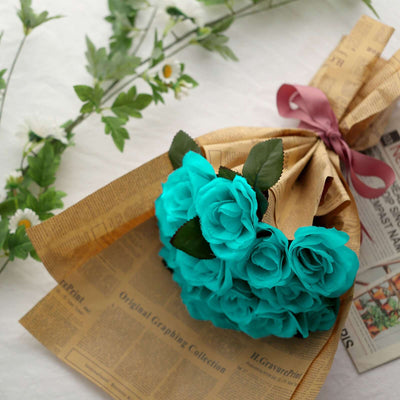 Bouquet of turquoise roses wrapped in newspaper with a ribbon.