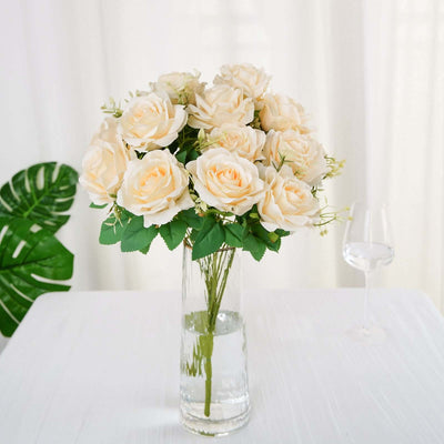 Artificial cream roses bouquet in a glass vase.