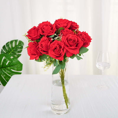 Red roses bouquet in a clear vase on a table.