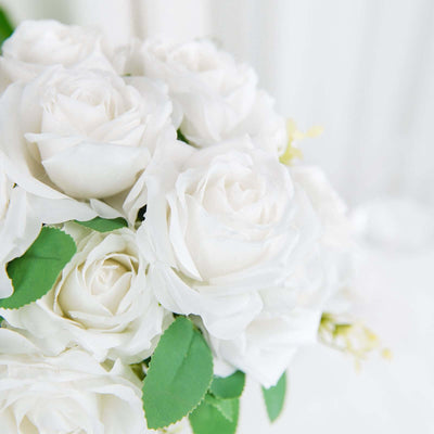 White roses bouquet with green leaves on a soft background.