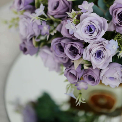 Purple rose bouquet with delicate flowers in a decorative vase.