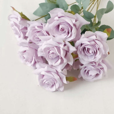 Lavender artificial roses bouquet on a plain background.
