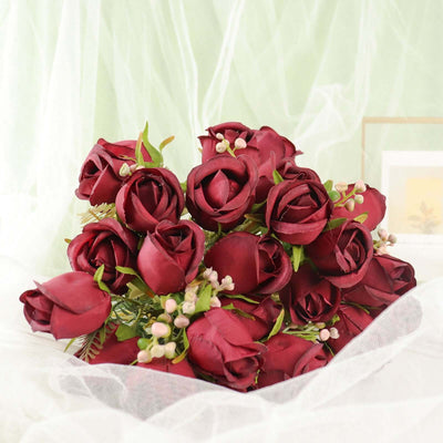 Artificial red rose bouquet with green accents on a soft background.