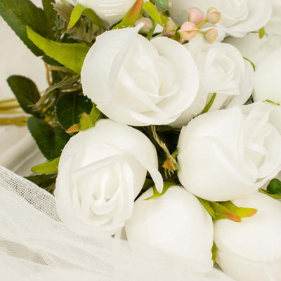 White artificial roses bouquet with greenery and delicate accents.