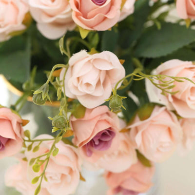 Pink and purple artificial roses in a decorative vase.