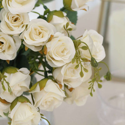 Artificial white rose bouquet with green accents in a decorative arrangement.
