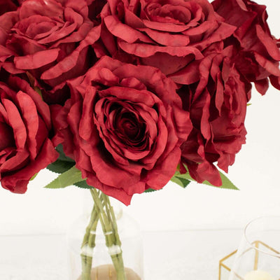 Red artificial roses bouquet in a clear vase.