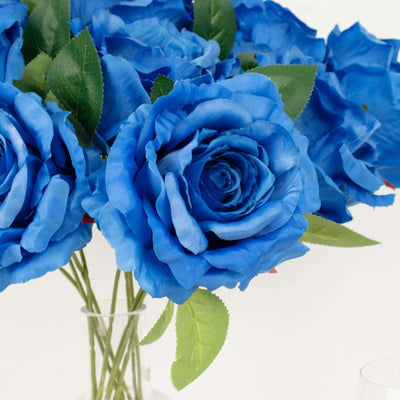 Blue artificial roses bouquet in a clear vase