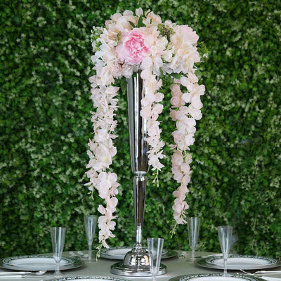 Elegant floral centerpiece with pink blooms on a tall silver vase.