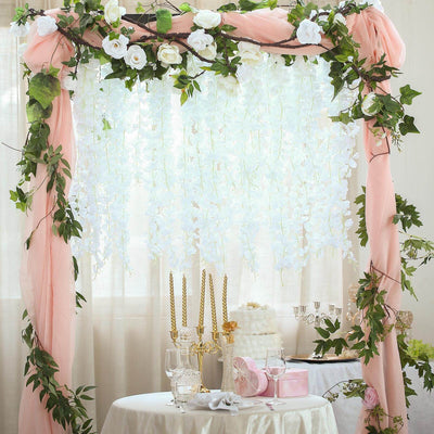 Wedding arch with floral decor and draped fabric for event decoration.