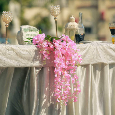 Pink floral arrangement draping over a table at a decorated event.