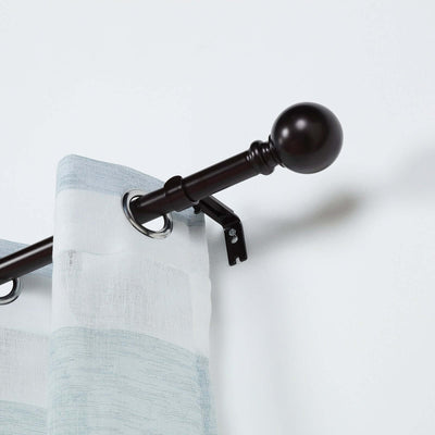 Gray and white striped curtain hanging on a dark rod with decorative finial.