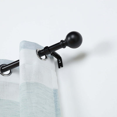 Black curtain rod with gray and white sheer curtains