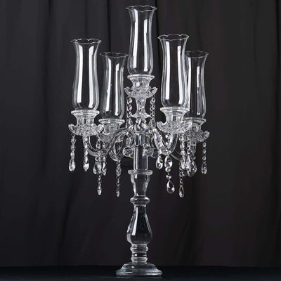Elegant crystal candelabra with five glass holders and hanging crystals.