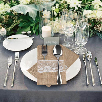 Burlap napkin with lace detail on a beautifully set dining table.