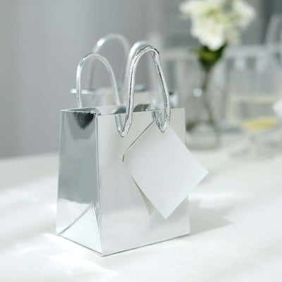Shiny silver gift bag with a blank tag on a table.