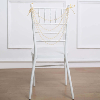 White chiavari chair adorned with pearl garlands.