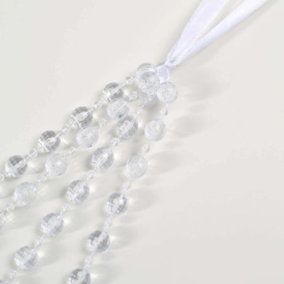 Clear beaded curtain strands with white ribbon.