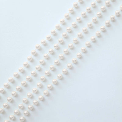 String of elegant white pearls on a soft blue background.