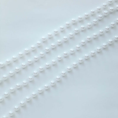 White pearl strands arranged in a row on a light background.