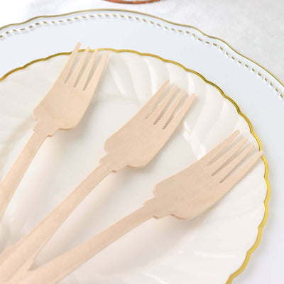 Wooden forks arranged on an elegant white plate with a gold rim.