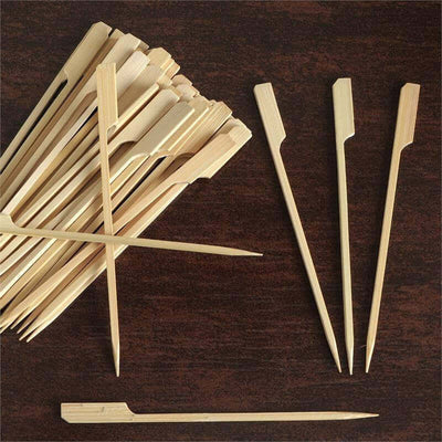 Bamboo skewers arranged on a wooden surface, showcasing various styles.