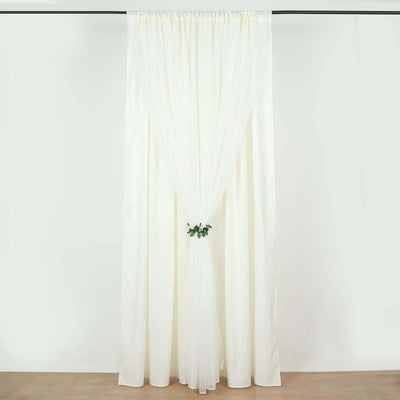 White sheer curtain with a gathered tieback and greenery accent