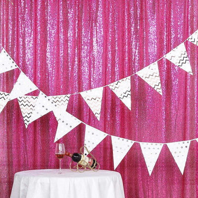 Party decoration with white bunting against a pink sequin backdrop.