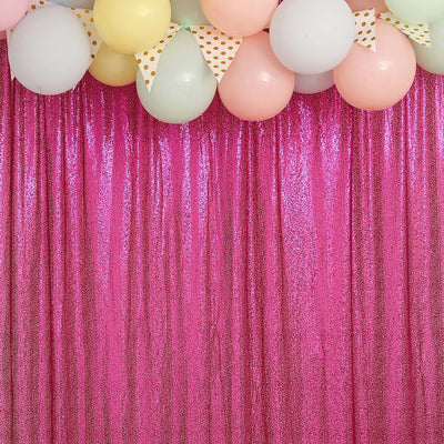 Colorful balloons above a sparkling pink sequin backdrop.