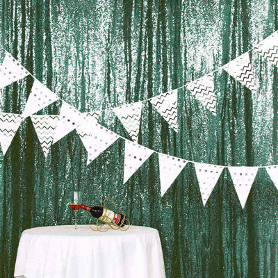 Decorative party bunting with black and white patterns against a sparkling green backdrop.