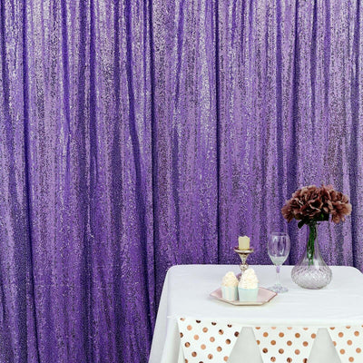 Purple sequin backdrop with table, vase, and decorative items for event styling.