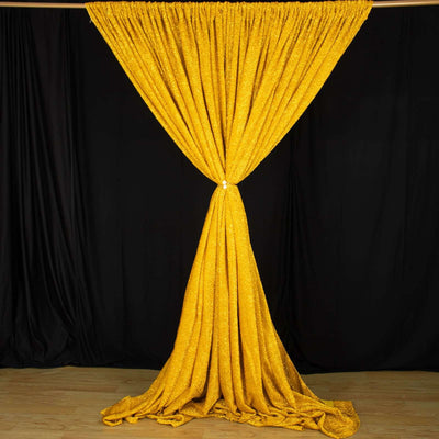 Shimmering yellow stage curtain draped elegantly against a black background.