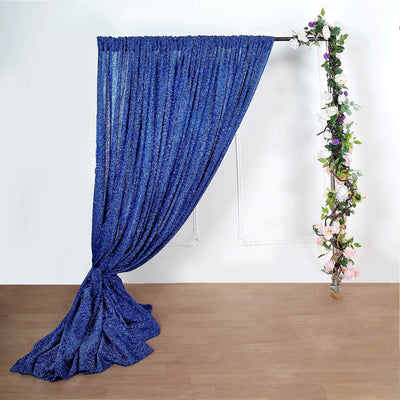Blue curtain draped elegantly with floral accents on a plain background.