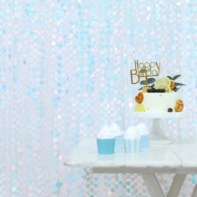 Birthday cake with festive decorations and cupcakes on a white table.