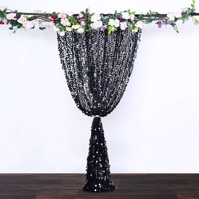 Black sequin curtain backdrop with floral accents for events and photography.