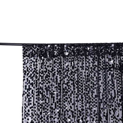 Black sequin curtain with pleats hanging on a rod