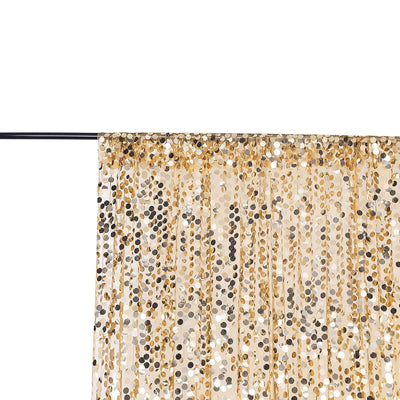 Gold and silver sequin curtain draped on a rod against a white backdrop