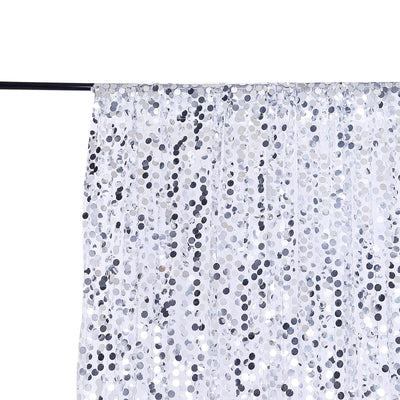 White and silver sequin curtain hanging from a black rod