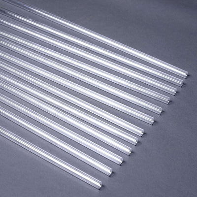 Clear acrylic rods arranged in a line on a gray surface.