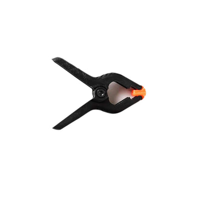Black plastic clamp with orange detail, studio shot.