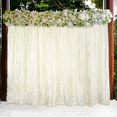 Elegant ivory ruffled backdrop adorned with a floral arrangement.