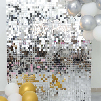 Silver mirrored backdrop with "Let's Party" neon sign and colorful balloons.
